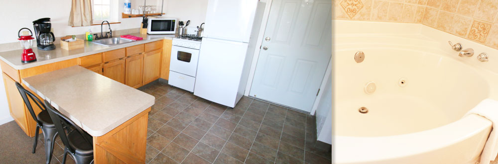 Photo of a kitchen with a counter, refrigerator, oven, sink and coffee maker. There are tile floors and two chairs.