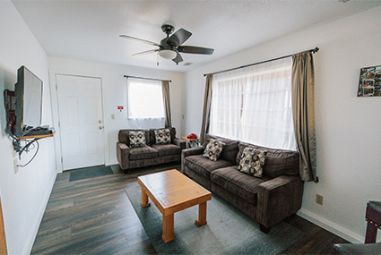 Photo of a living room. There is a couch, coffee table, and television.